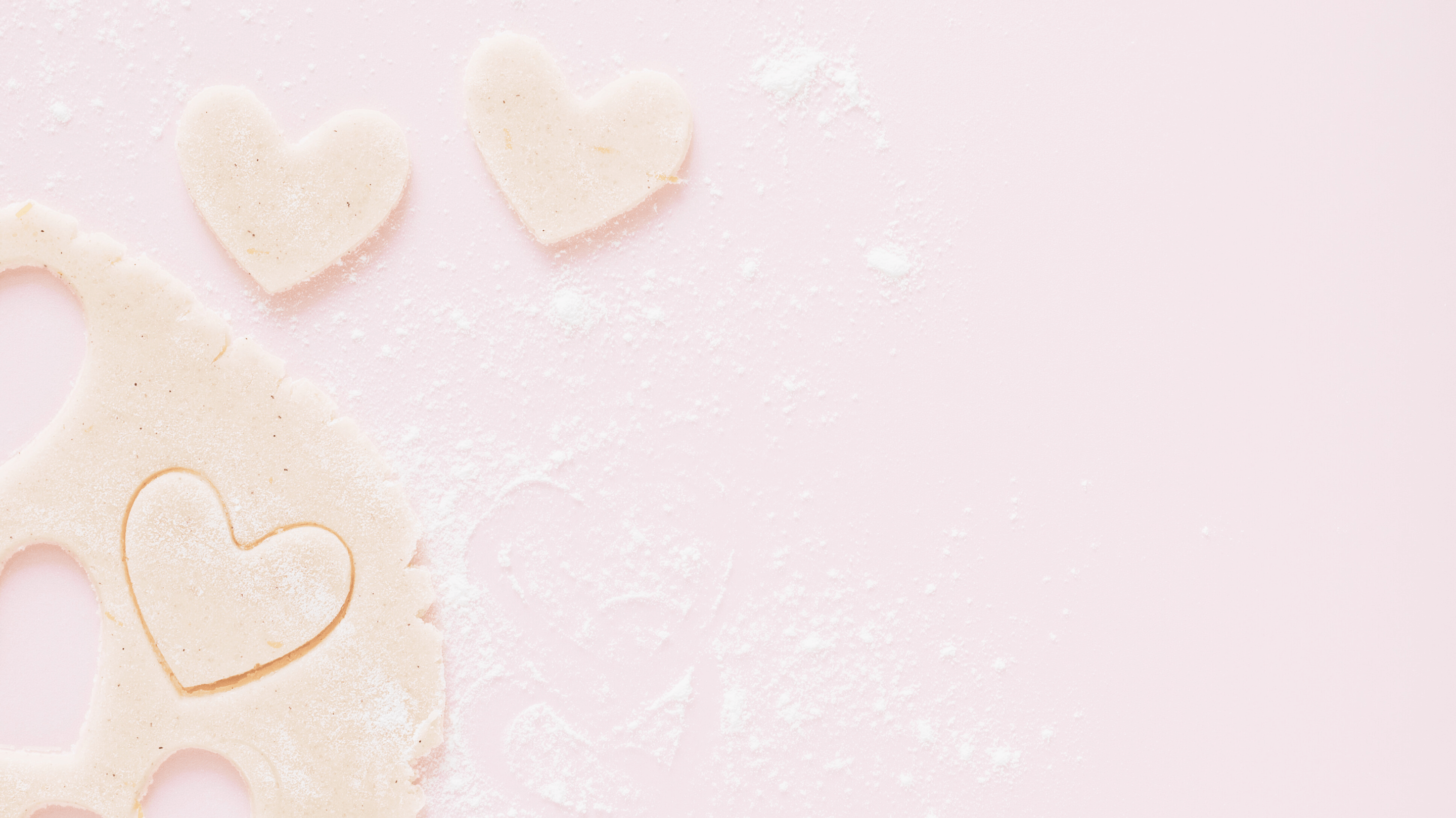 heart shaped sugar cookie dow cut outs on a pink table.