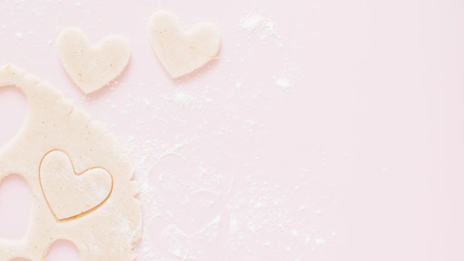 heart shaped sugar cookie dow cut outs on a pink table.