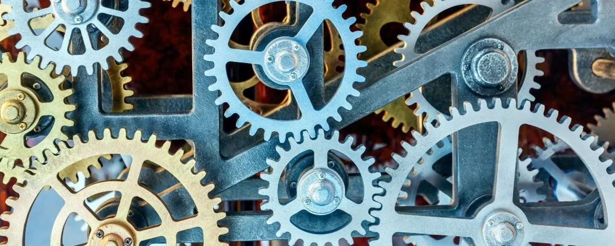 A close-up of interlocking brass and steel gears in a machine, all turning together.