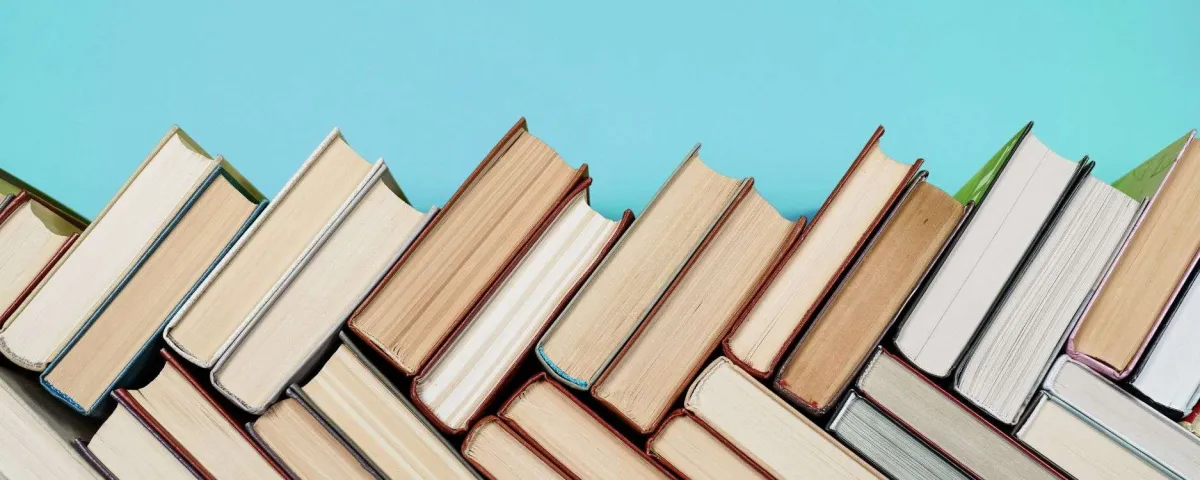 Books stacked in a herringbone pattern for blog post "These 4 Marketing Books Will Change Your Business Forever"