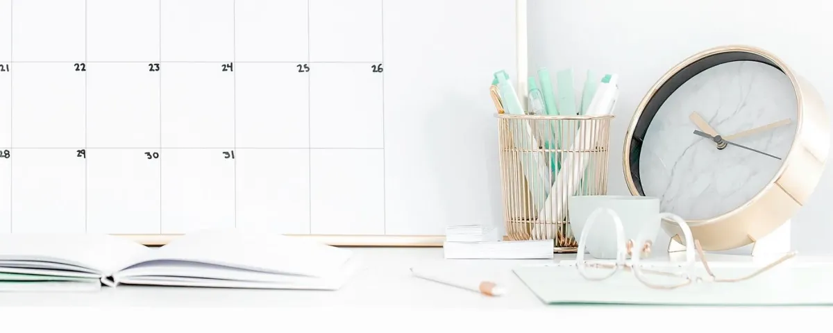 desk with a calendar, clock, and mint-green accessories