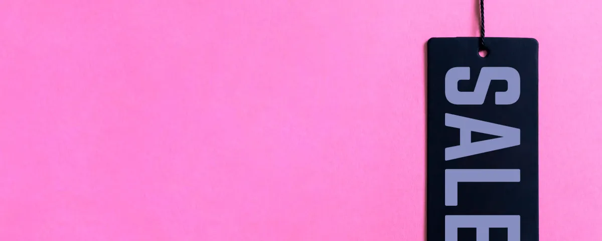 Black Friday sale tag hanging against a hot pink background.