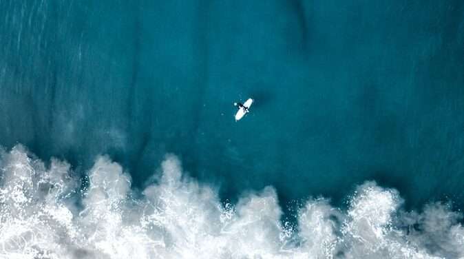 an aerial view of a surfer riding a wave