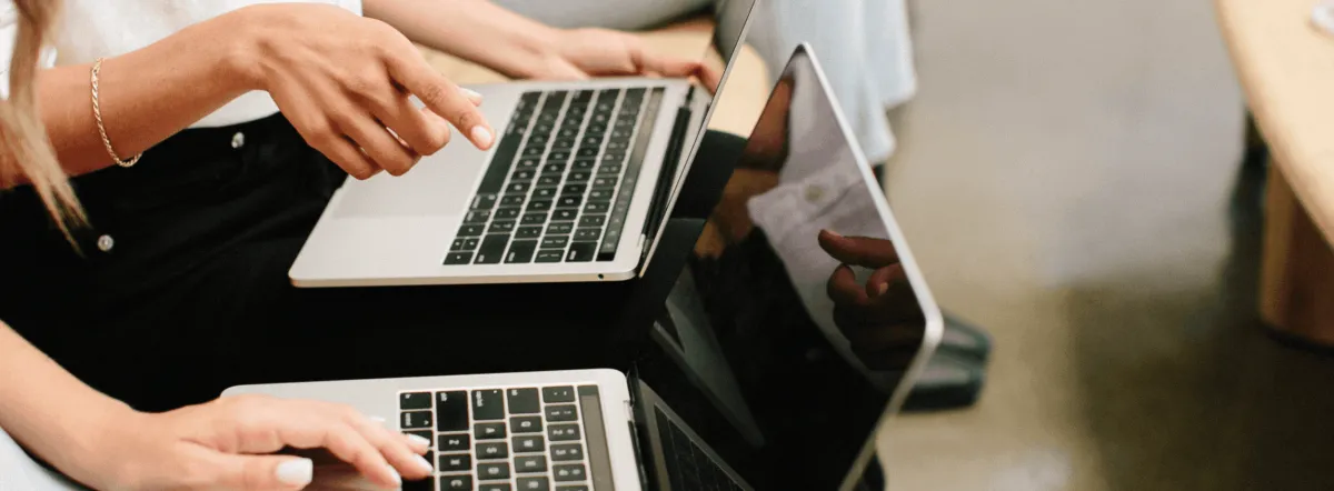 Two people working on laptops doing social media marketing