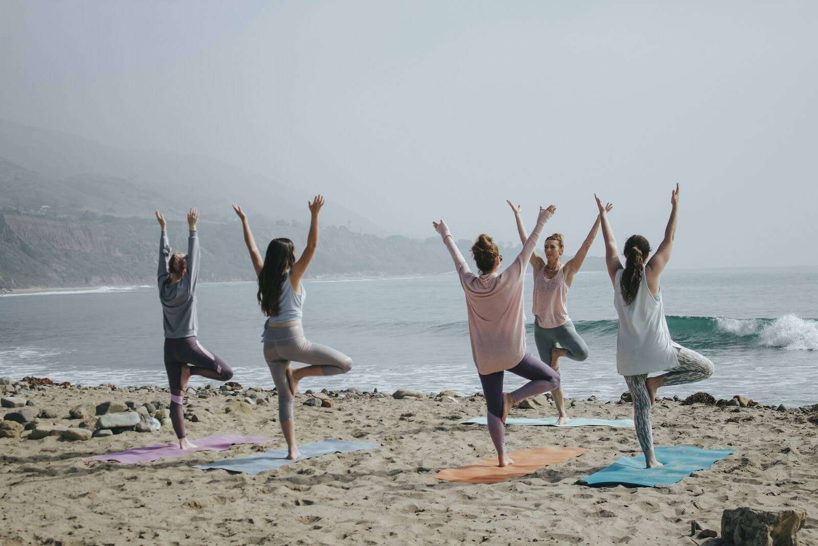 five woman in an exercise class on the beach