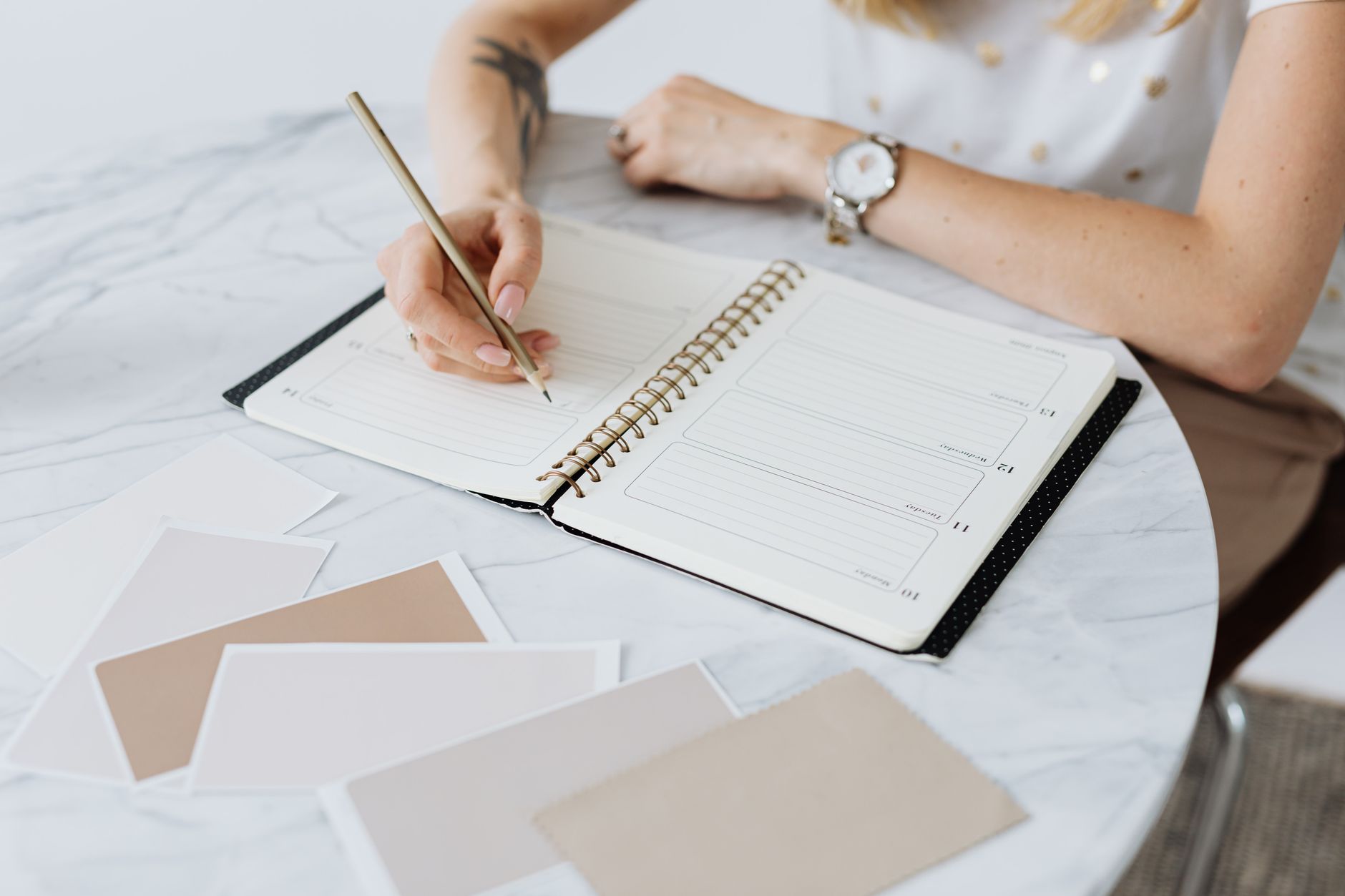 Woman writing in her planner following the mid-year marketing reset for coaches.