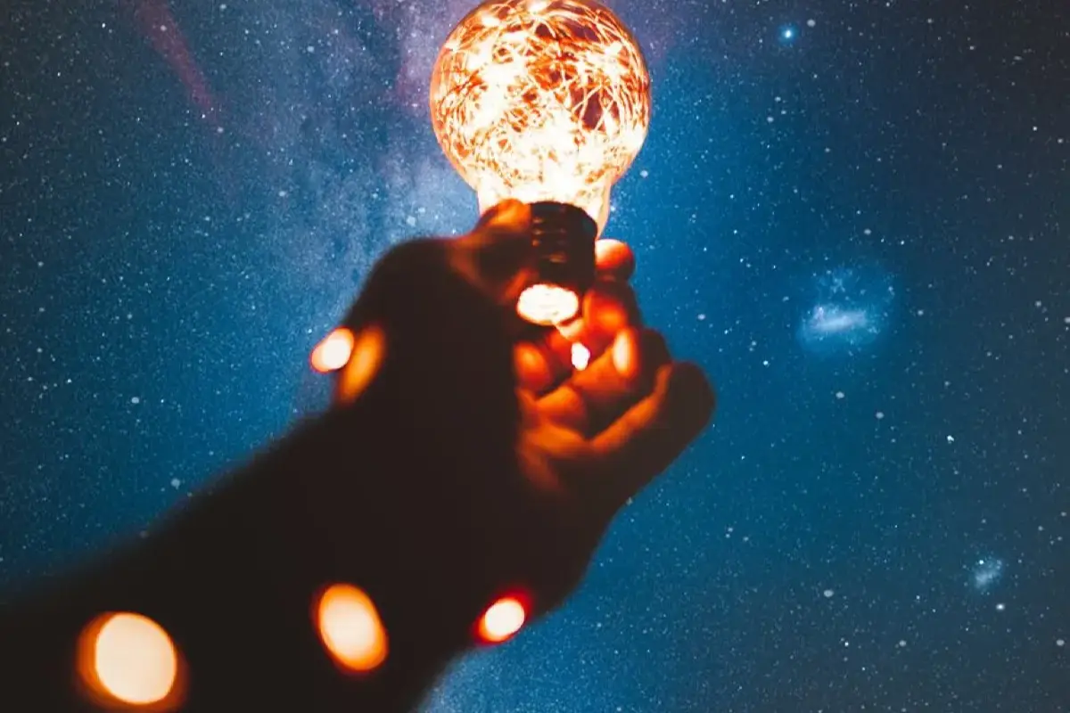 Person holding a light blub representing genius content.