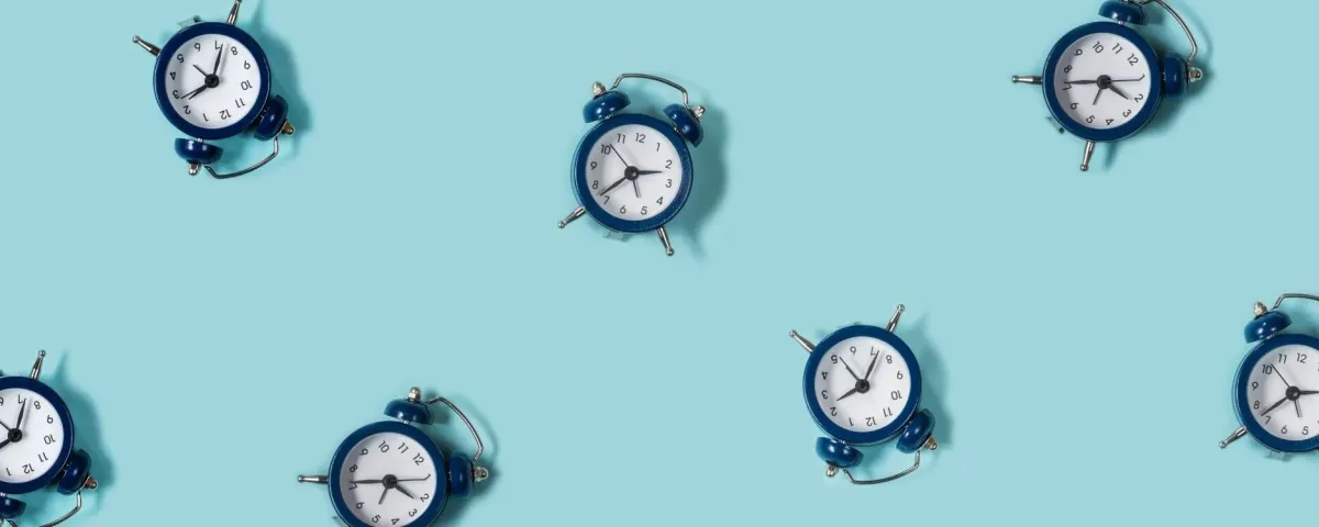a bunch of navy blue alarm clocks scattered on a turquoise background