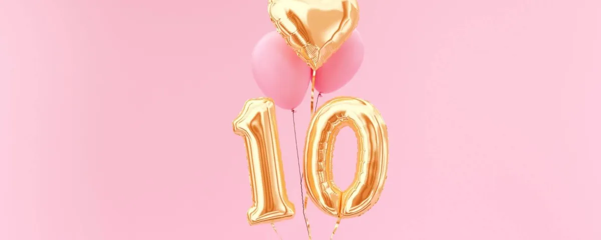 gold balloons in the shape of a number 10 on a pink background