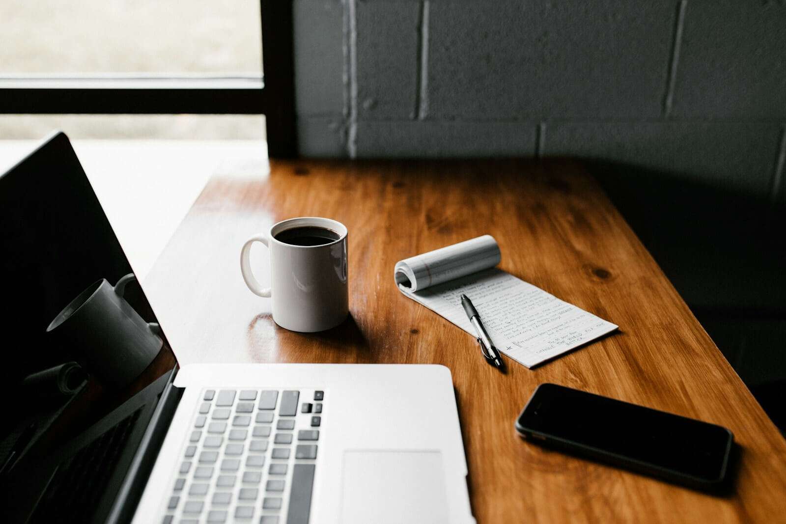 mug and laptop on a desk - creating content
