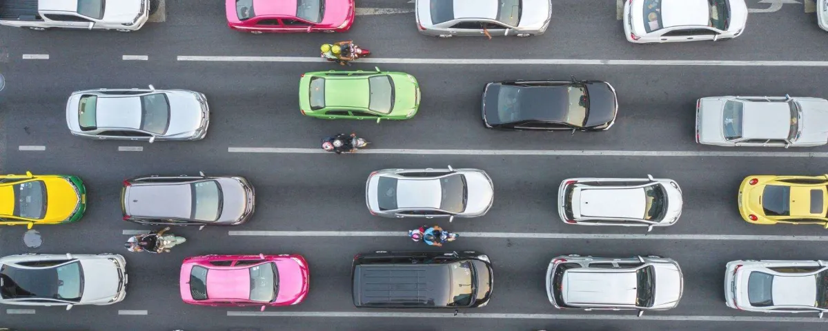 an overhead view of a four-lane road showing colorful cars in bumper to bumper traffic