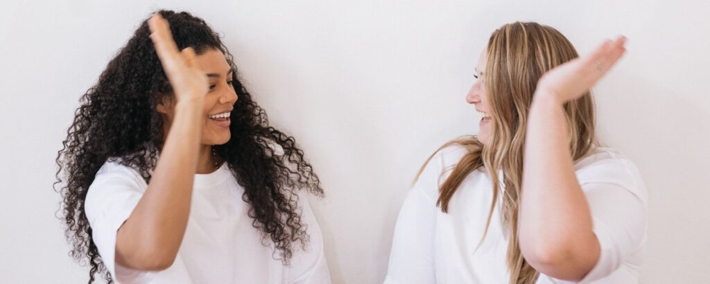 two friends doing a high-five. Are You Marketing Your Business or Making Friends?