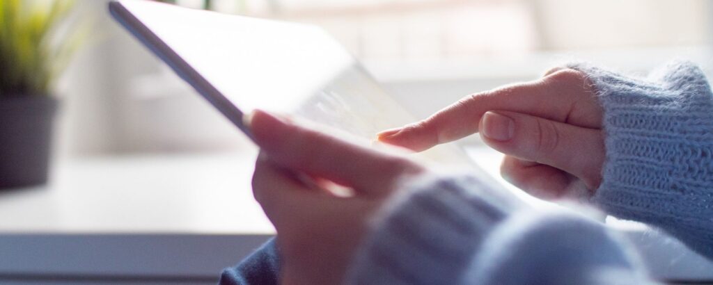 hands holding an ipad scrolling through a website "How to Build Authority with Your Website"