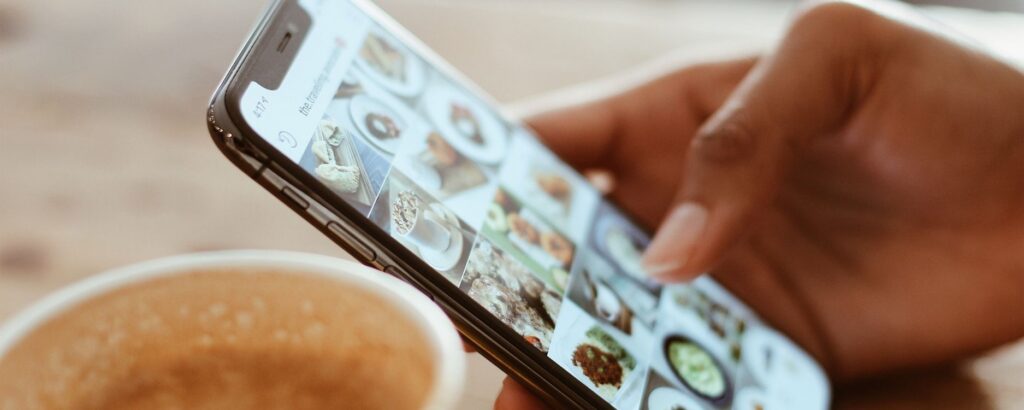 Person's hand scrolling through content on their phone. "How to Promote Content Efficiently and Effectively"