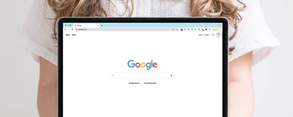 Woman holding a laptop that shows the Google search screen