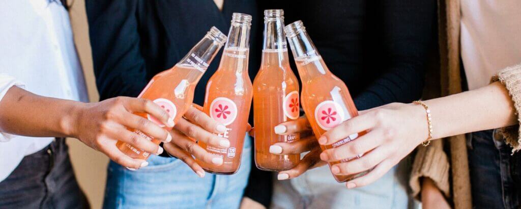 group of hands holding a soda bottle at a networking meeting or party