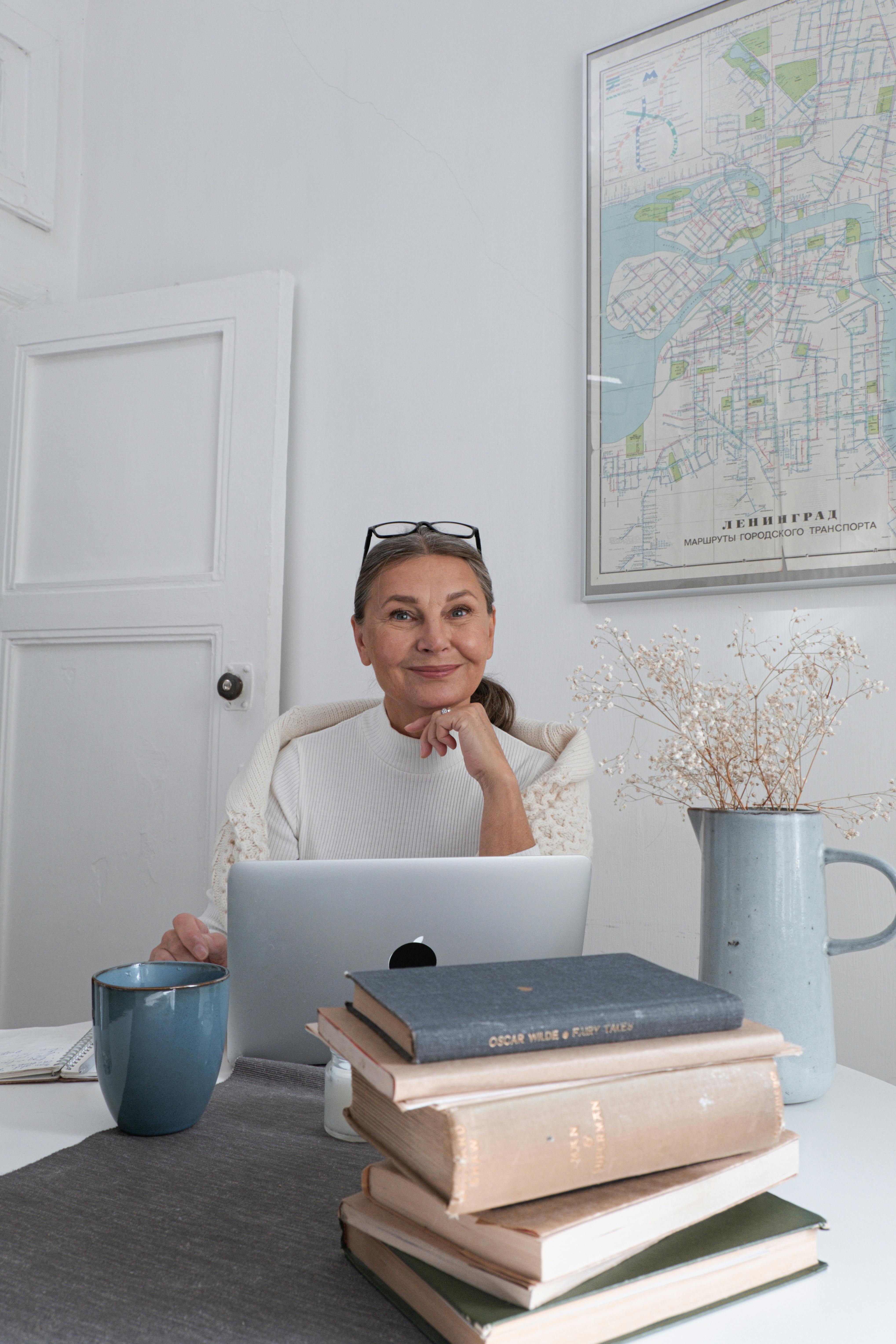 coach working on laptop creating long-form content in her pretty home office