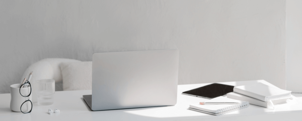 gray desk with laptop glasses, office supplies, etc.