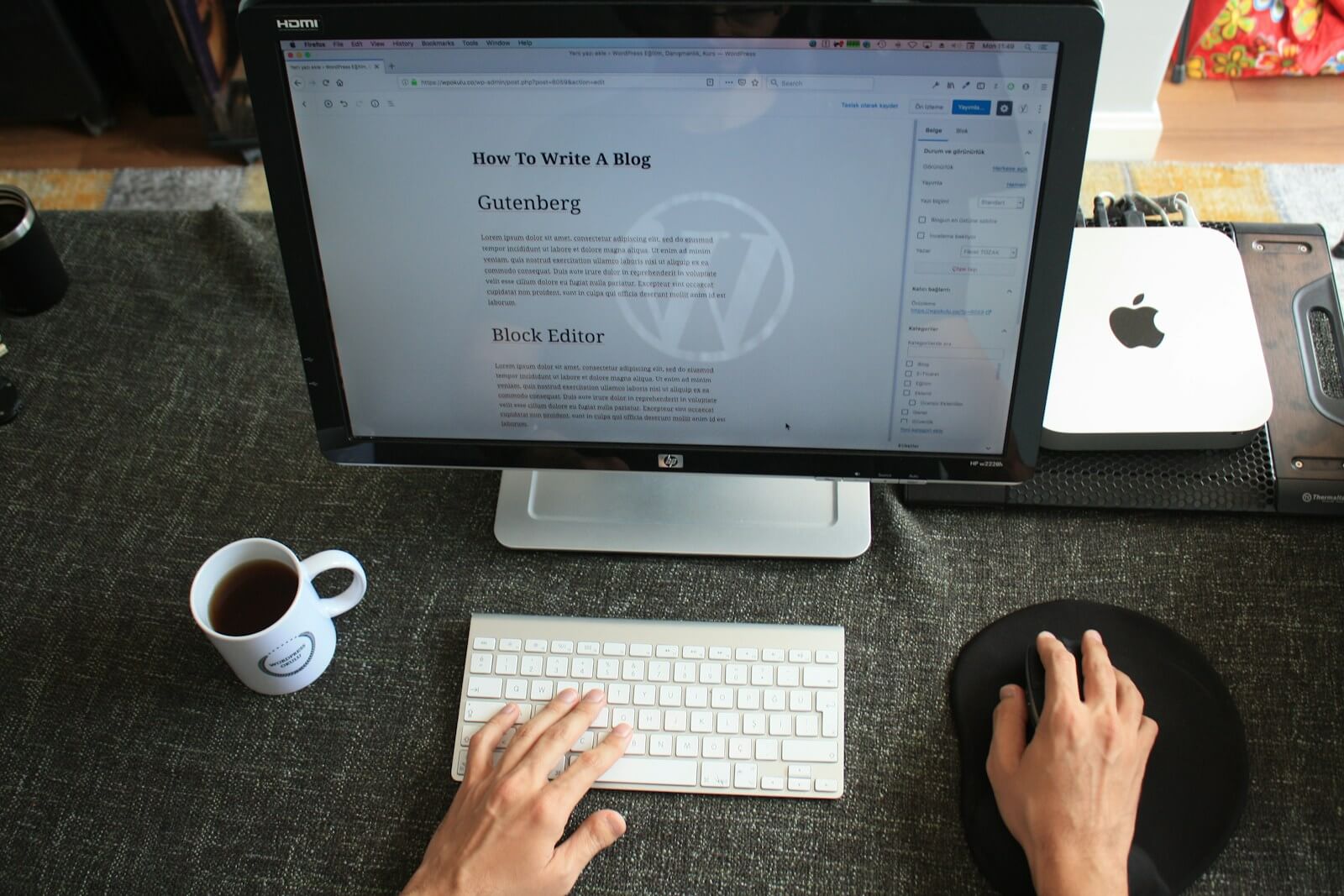 computer monitor showing a wordpress website on the screen with hands on the keyboard and mouse.