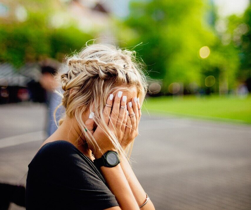 shy woman hiding her face afraid to be seen