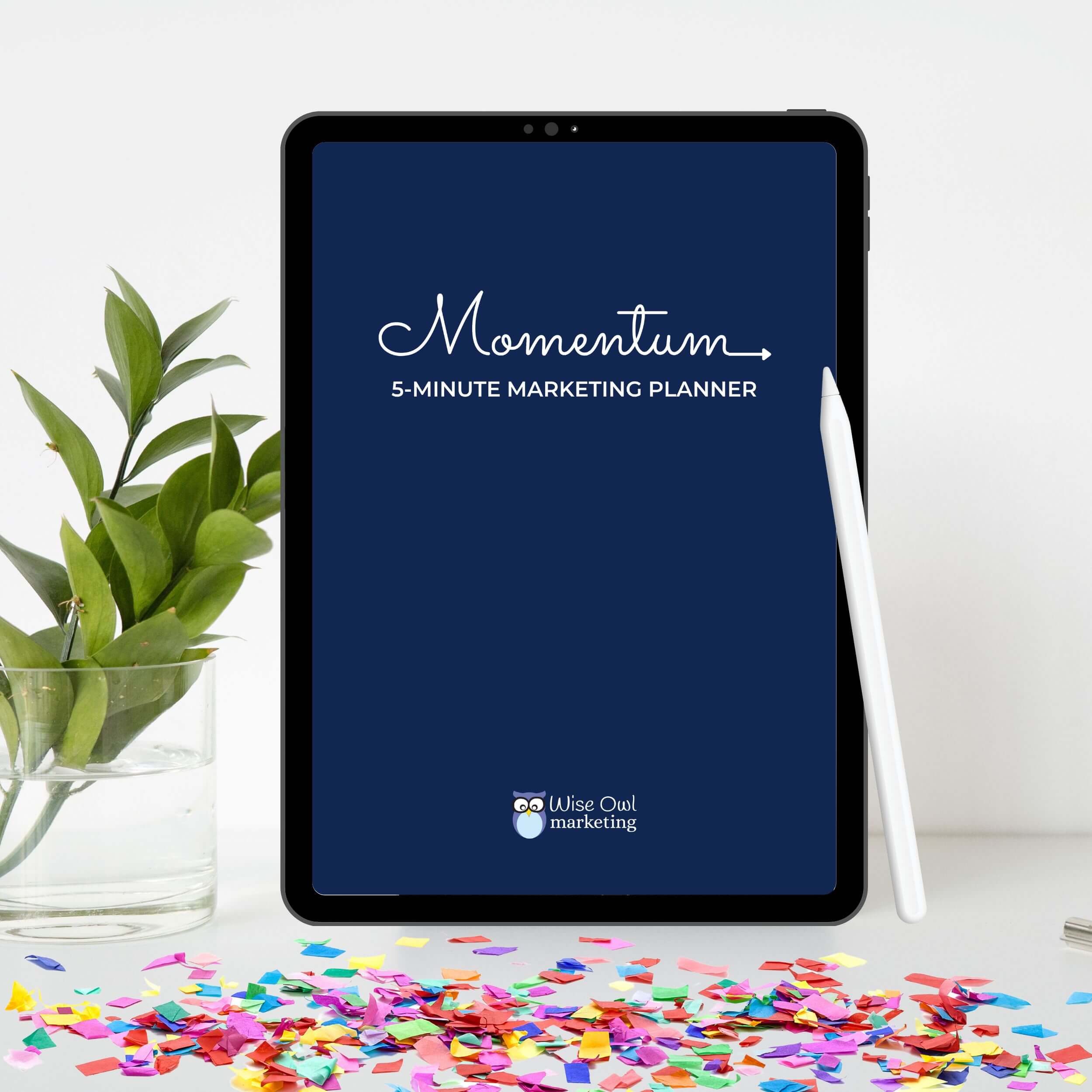 ipad mockup of the momentum marketing planner with confetti on the desk