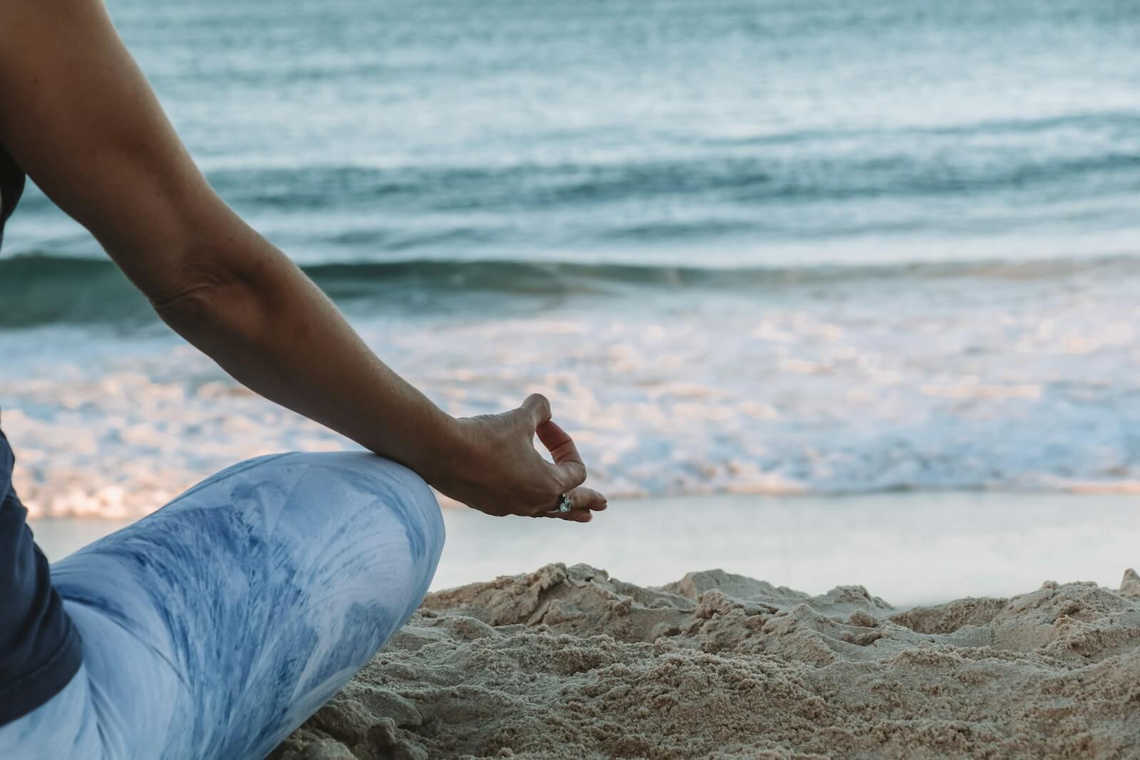 person meditating on the beach shore during daytime