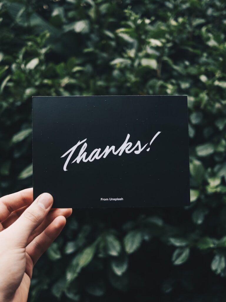 Send handwritten notes to show customer appreciation : person holding Thanks card