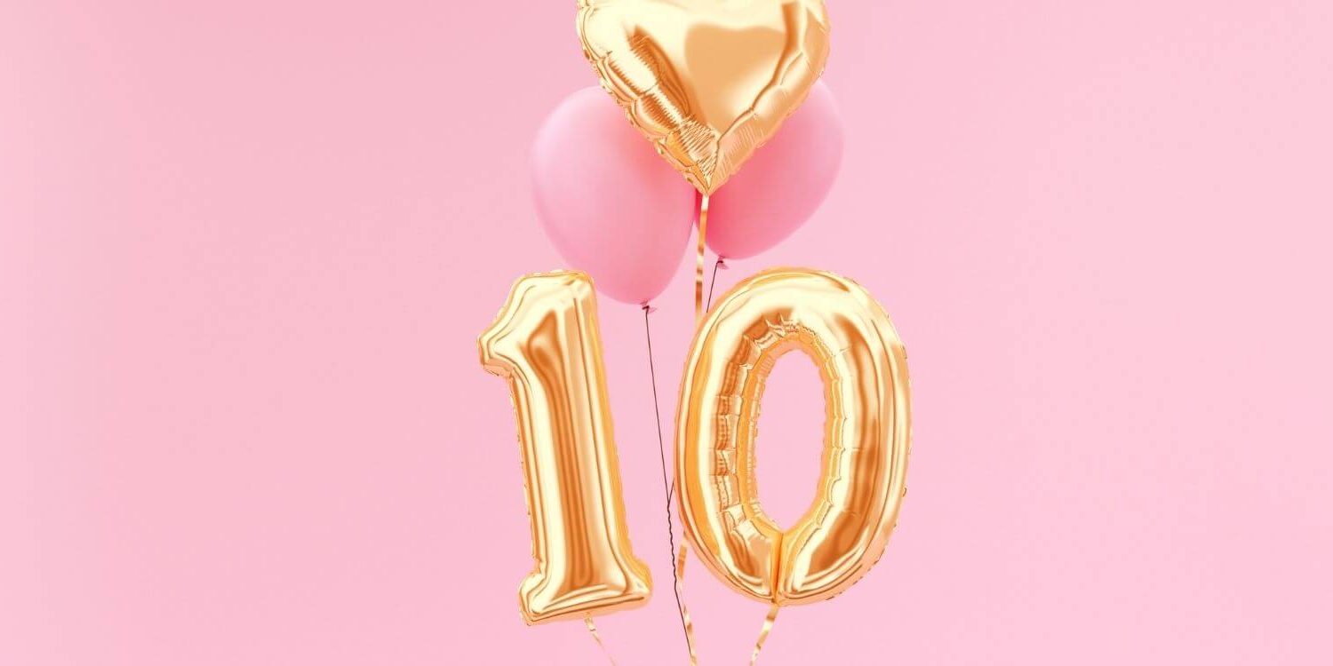 gold balloons in the shape of a number 10 on a pink background