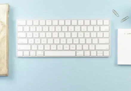 blue background with a journal, keyboard, candle and writing utensils