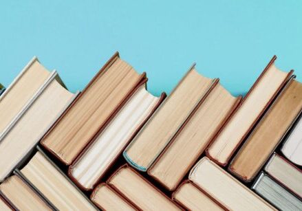 Books stacked in a herringbone pattern for blog post "These 4 Marketing Books Will Change Your Business Forever"