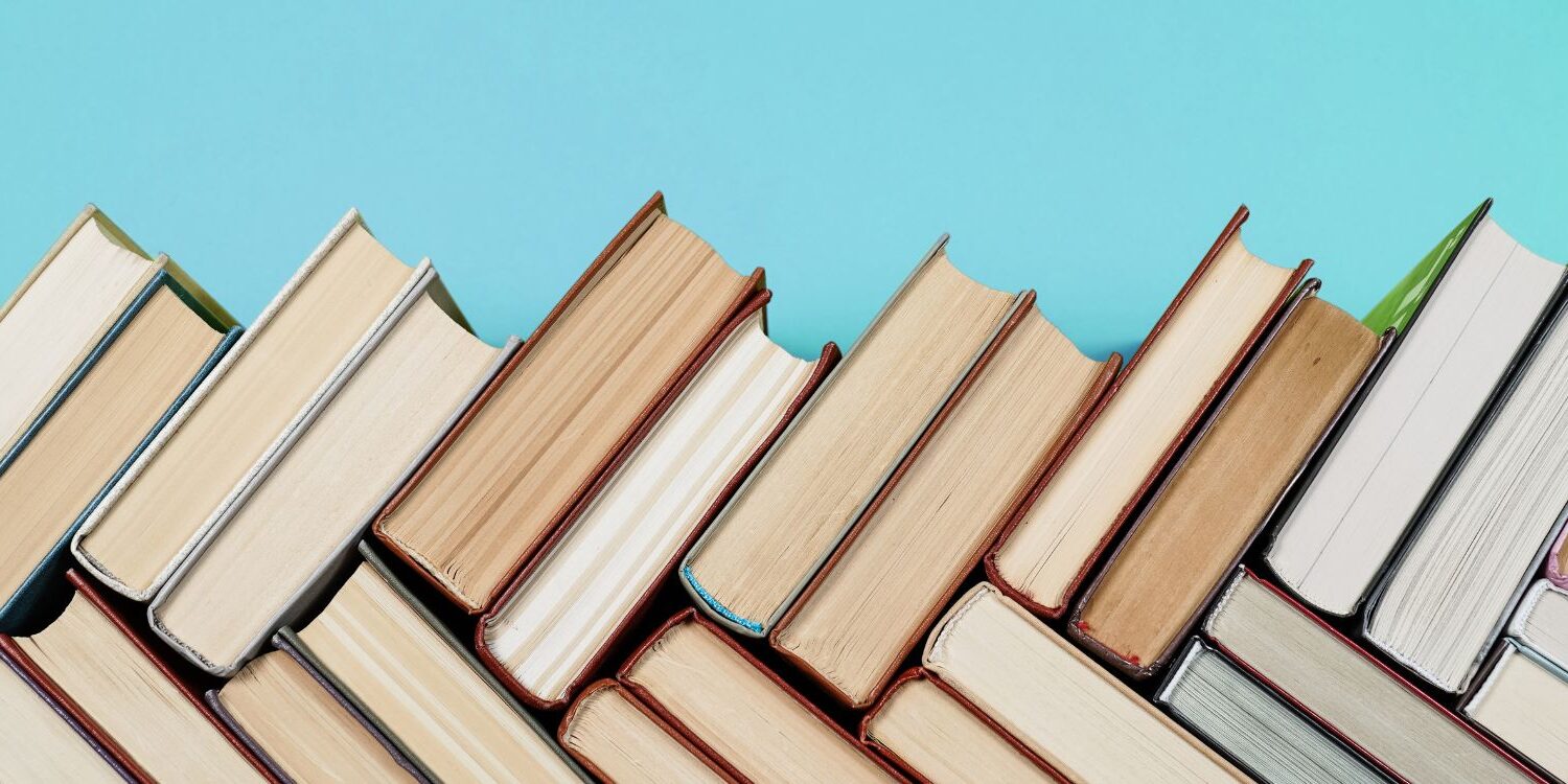 Books stacked in a herringbone pattern for blog post "These 4 Marketing Books Will Change Your Business Forever"