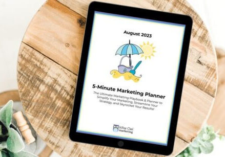 a round wooden table with an ipad on top showing the 5-minute marketing planner on the screen