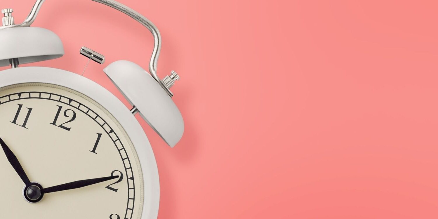 alarm clock on a pink background for blog post image " 5 Easy Ways to Find Time to Build Your Funnel When You’re Already Overbooked"