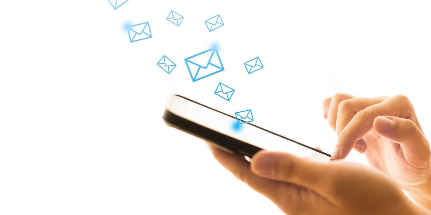 isolated image of a pair of hands scrolling through a phone with email envelopes floating out of it