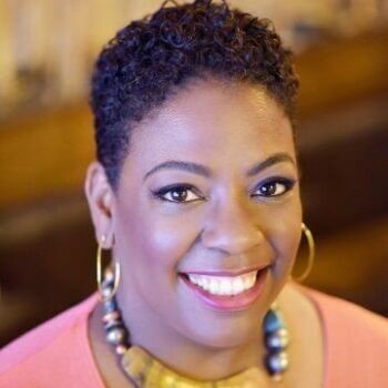 A beautiful African American woman with short hair, a necklace and earrings.
