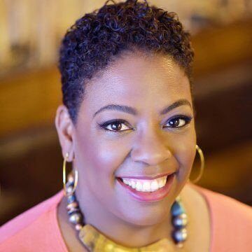 A beautiful African American woman with short hair, a necklace and earrings.