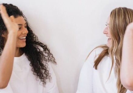 two friends doing a high-five. Are You Marketing Your Business or Making Friends?