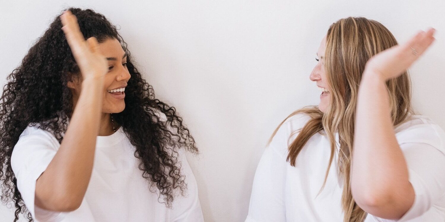 two friends doing a high-five. Are You Marketing Your Business or Making Friends?