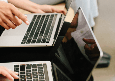 Two people working on laptops doing social media marketing