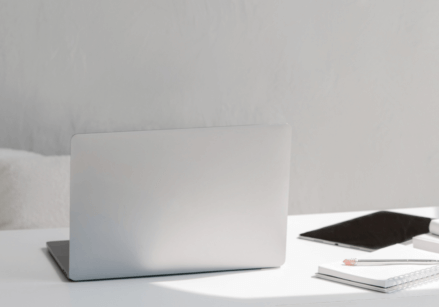 gray desk with laptop glasses, office supplies, etc.