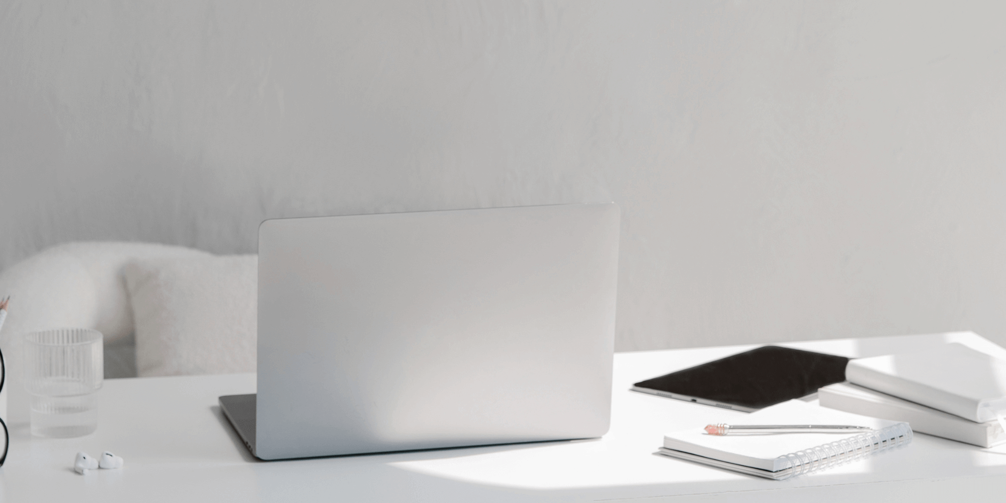 gray desk with laptop glasses, office supplies, etc.
