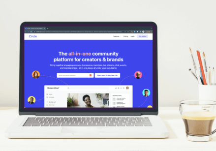 desk with a plant, books, pencil cup and laptop with the circle community on the screen.