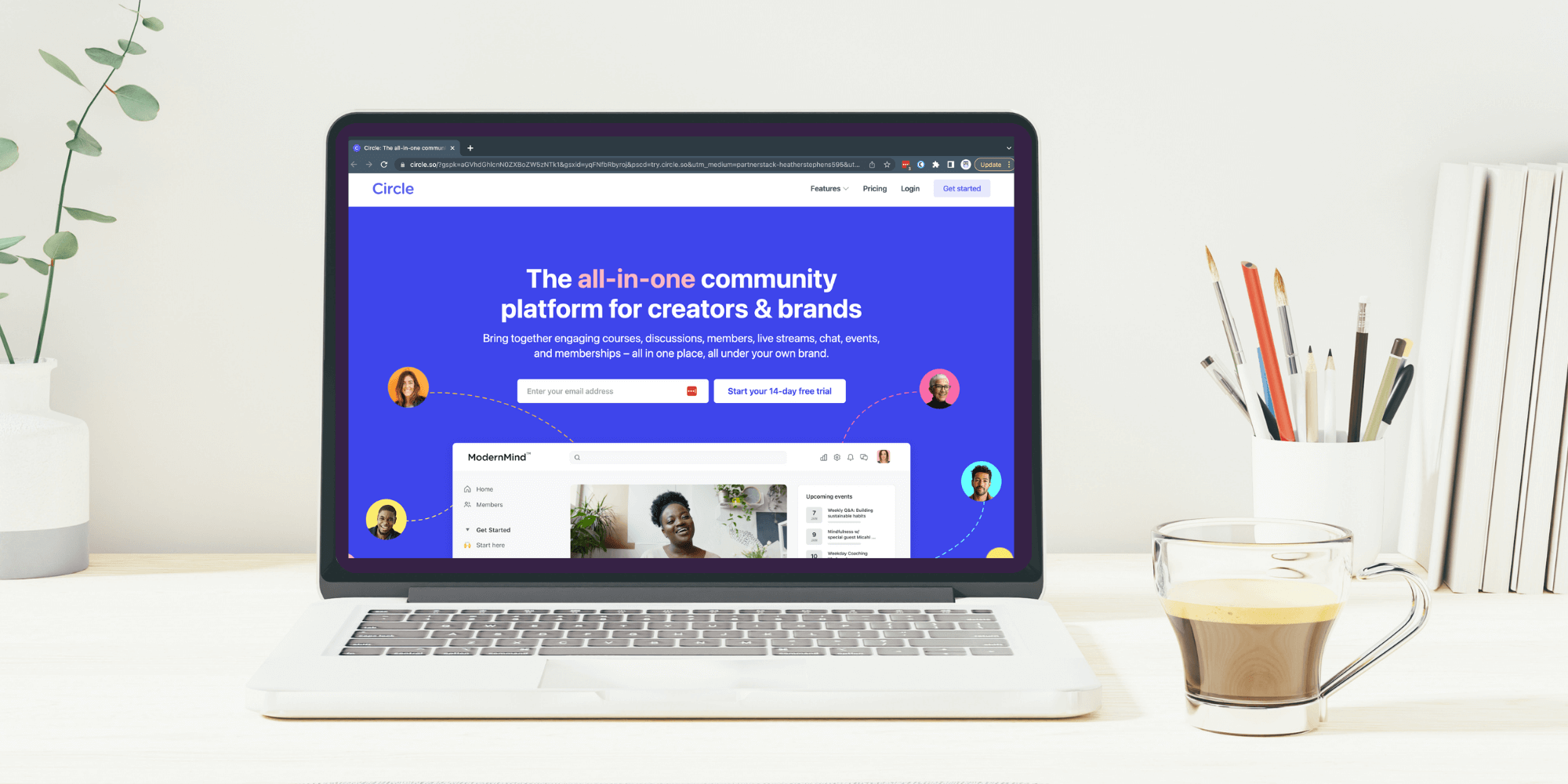 desk with a plant, books, pencil cup and laptop with the circle community on the screen.