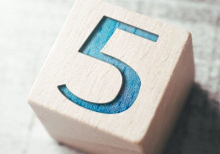 wooden block with the number 5 stamped into it and painted turquoise