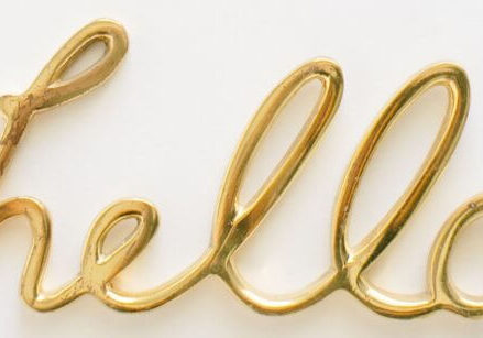 gold balloon letters spelling out the word hello on a white background