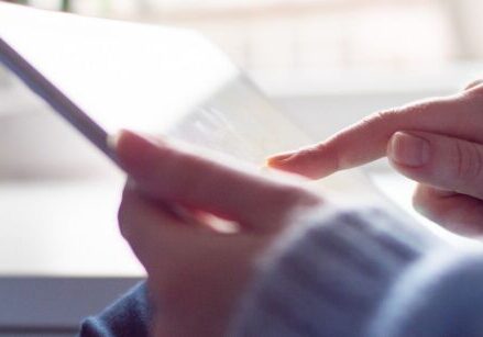 hands holding an ipad scrolling through a website "How to Build Authority with Your Website"