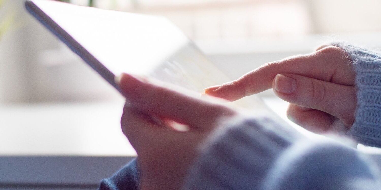 hands holding an ipad scrolling through a website "How to Build Authority with Your Website"