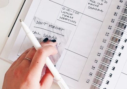 Woman trying to organize her busy schedule in a paper day planner