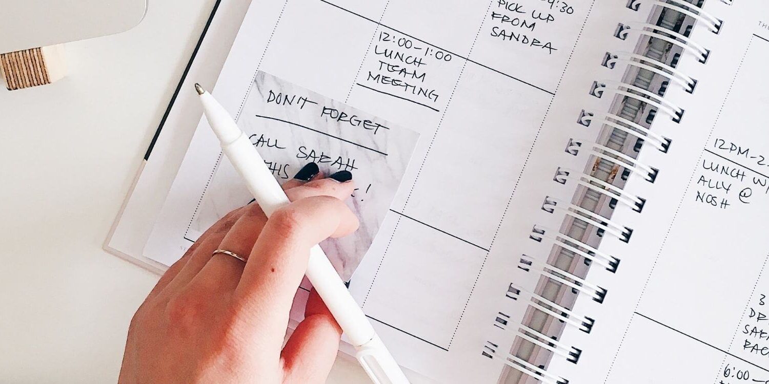 Woman trying to organize her busy schedule in a paper day planner