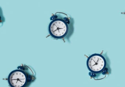 a bunch of navy blue alarm clocks scattered on a turquoise background